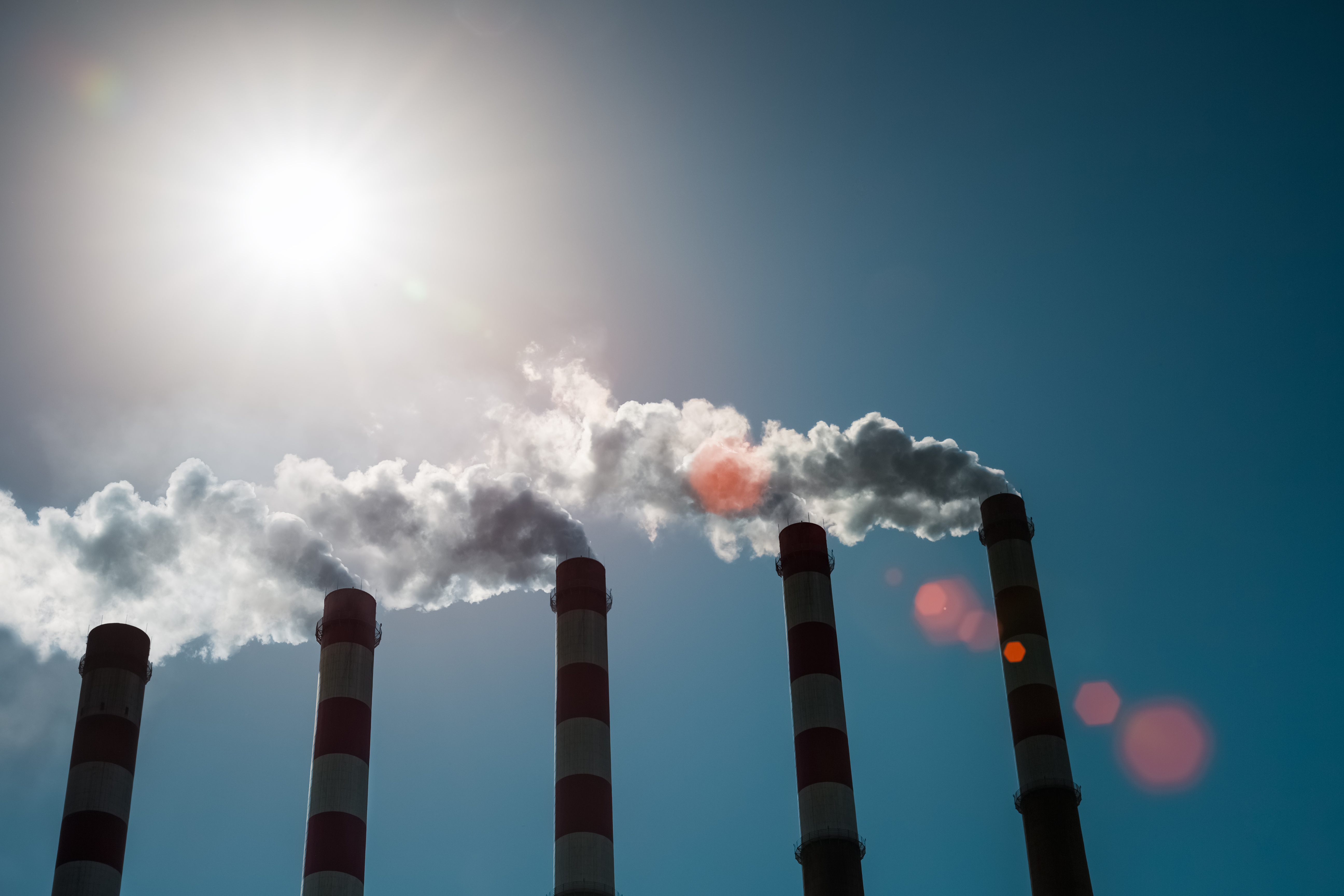 An image of chimneys emitting smoke into the air. 