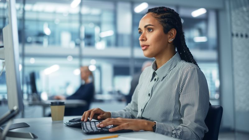 An image of a woman working at a computer 