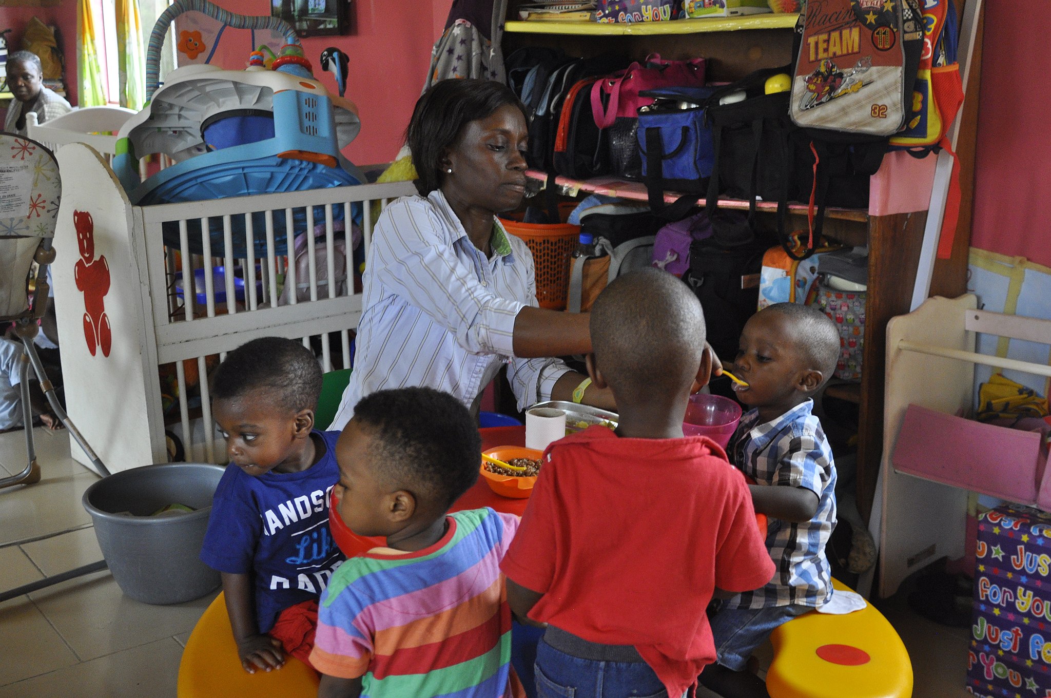 Woman at daycare center feeds children