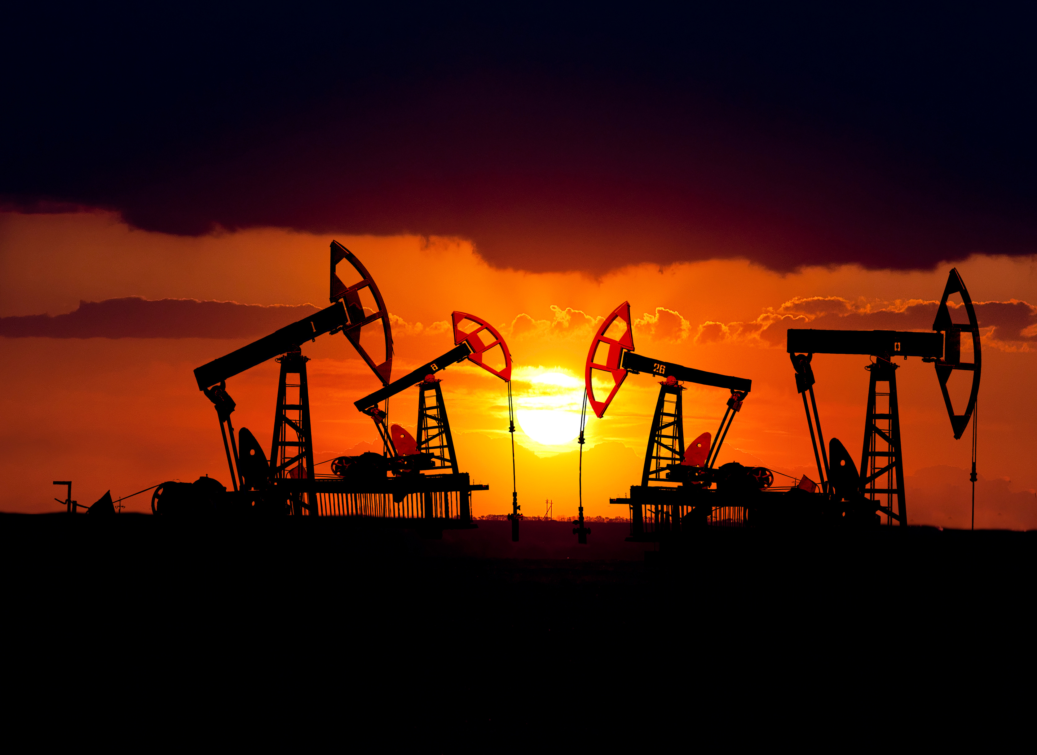 Oil rigs on oil field at sunset