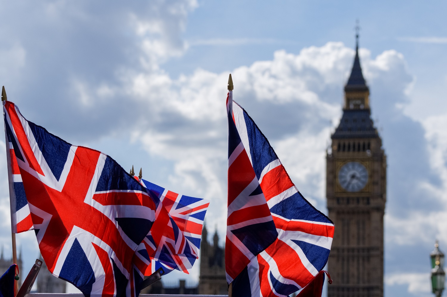 Image of UK flag in front of Elizabeth Tower in London, England