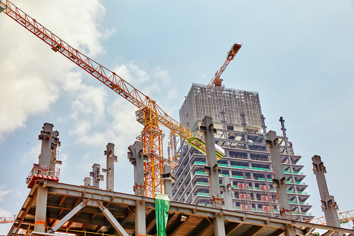 A photo of a construction crane and a half-finished building