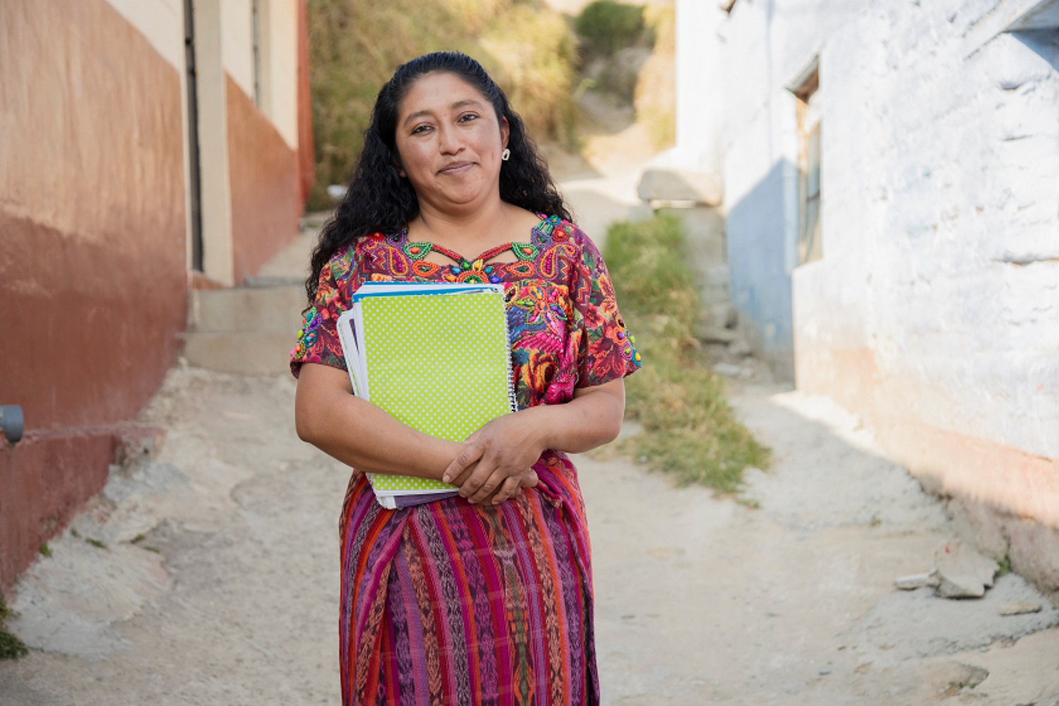 Teacher carrying notebooks