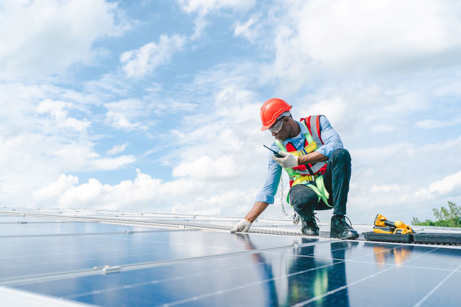 Engineer maintaining solar cell panels on factory building rooftop
