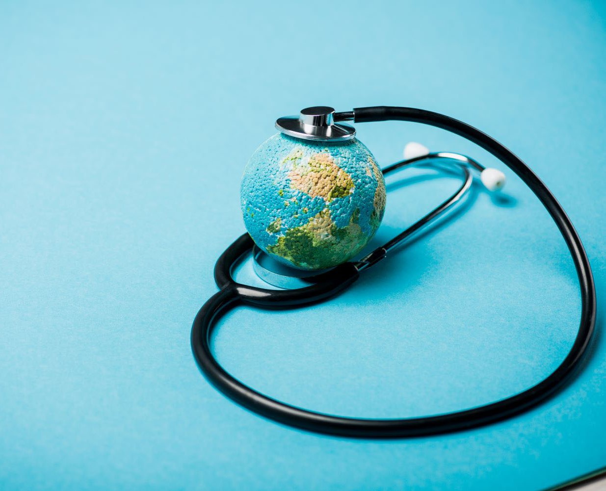 Stethoscope with globe on blue background