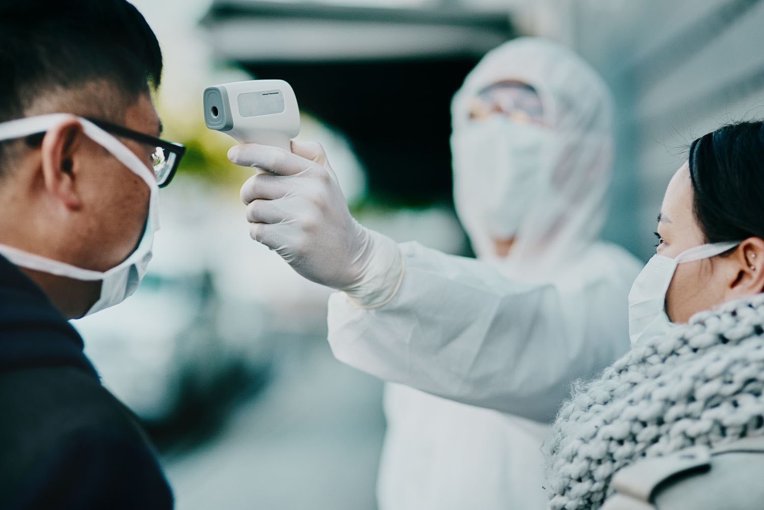 Medical safety officer doing a covid check on a man at the entrance to prevent the spread of the virus