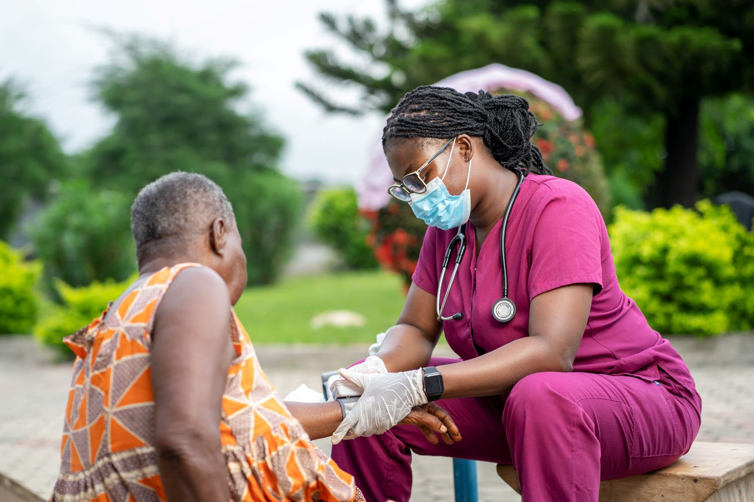 image of nurse in facemask, diagnosing senior woman outside- homecare service concept