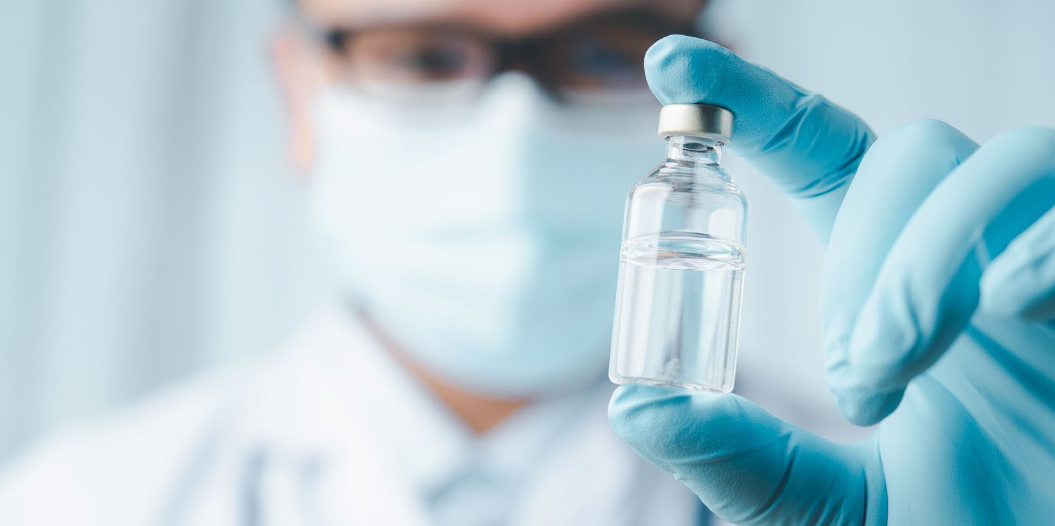 Doctor holding vial with vaccine inside