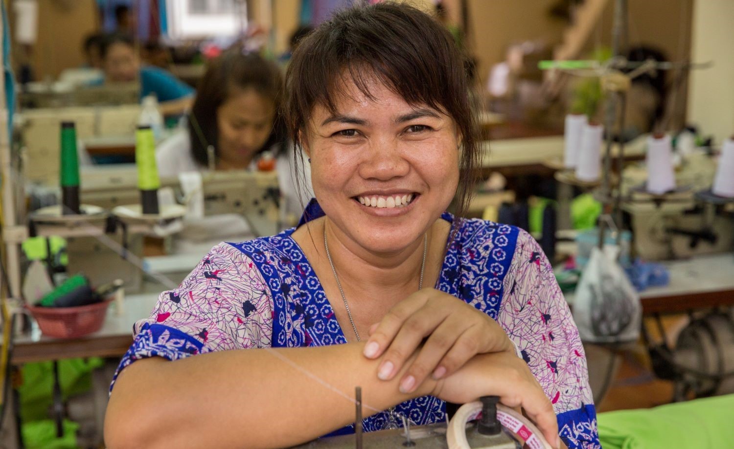 Woman sews garments at a unique workers'-owned factory on the outskirts of Bangkok.