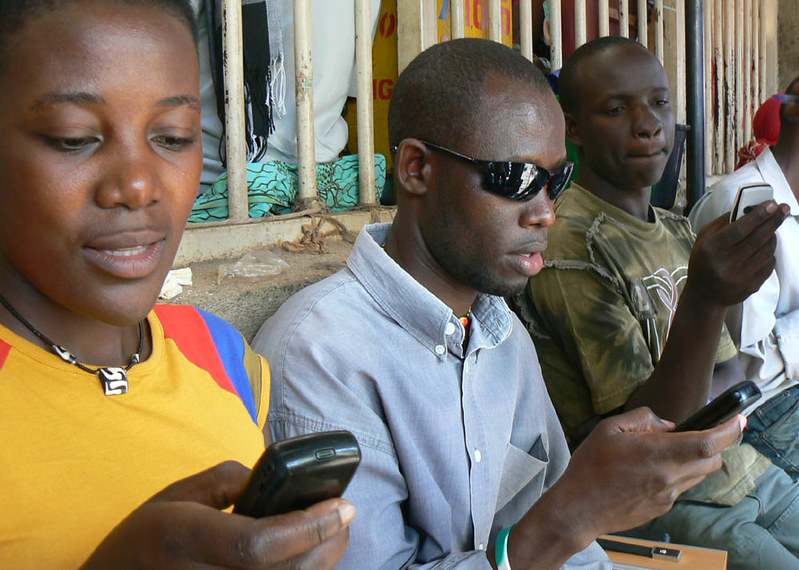 Ugandans texting on cellphones