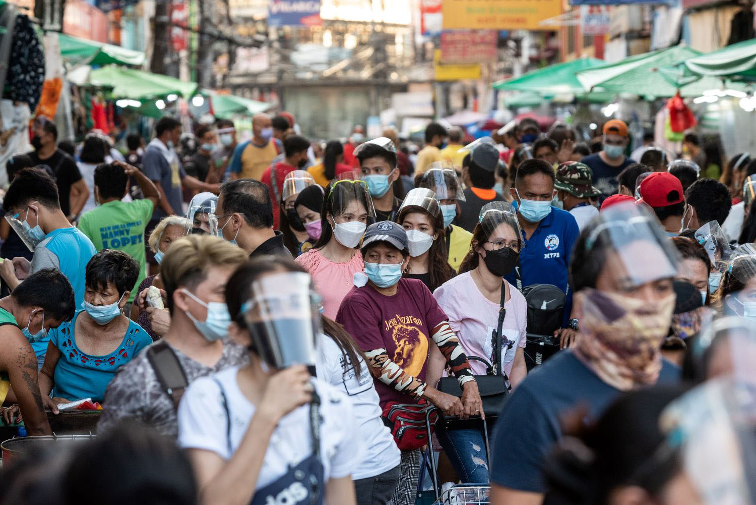 People walk past various stores in Quiapo.