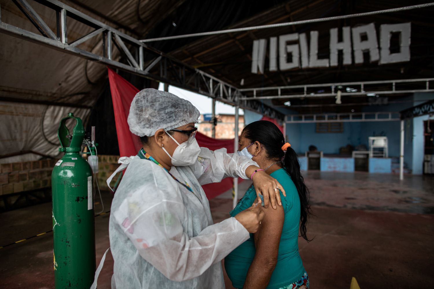 A professional from the health department applies a dose of the vaccine against covid-19 