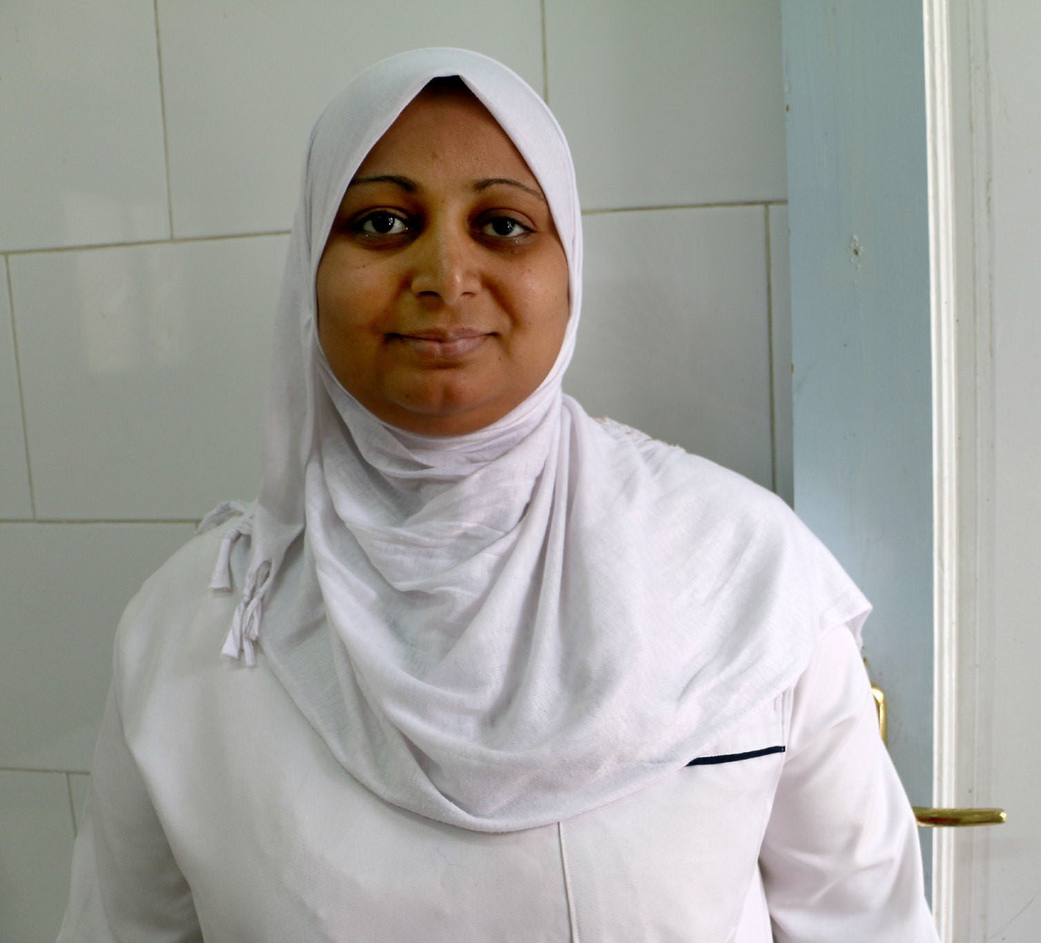 A nurse at Al Awameya Health Clinic in Luxor, Egypt stands outside a treatment room during a USAID site visit