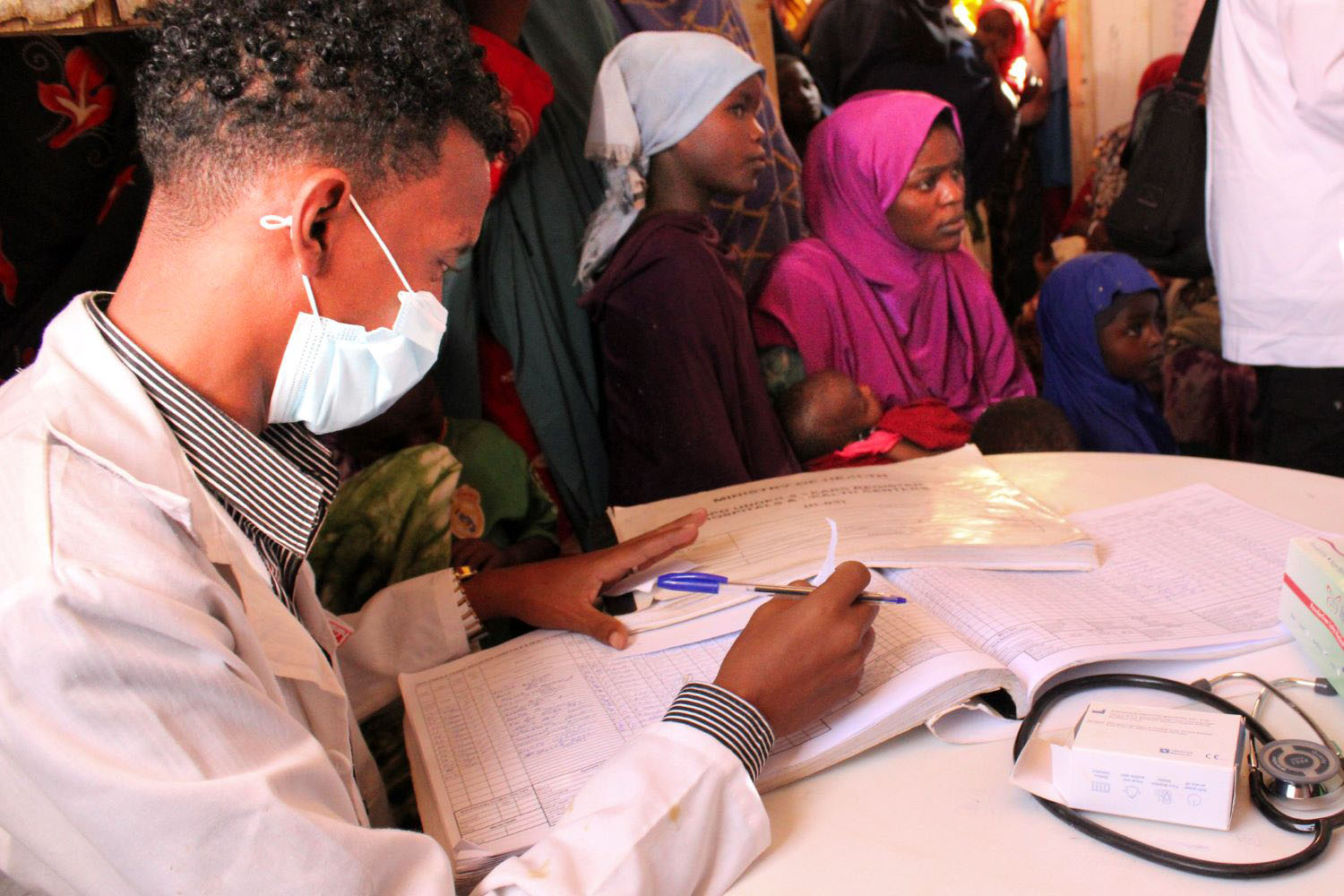  Sitting at the table and recording the childrenâs names and vaccinations is Dr. Bashir Ali. The Jawle Health Center in Garowe