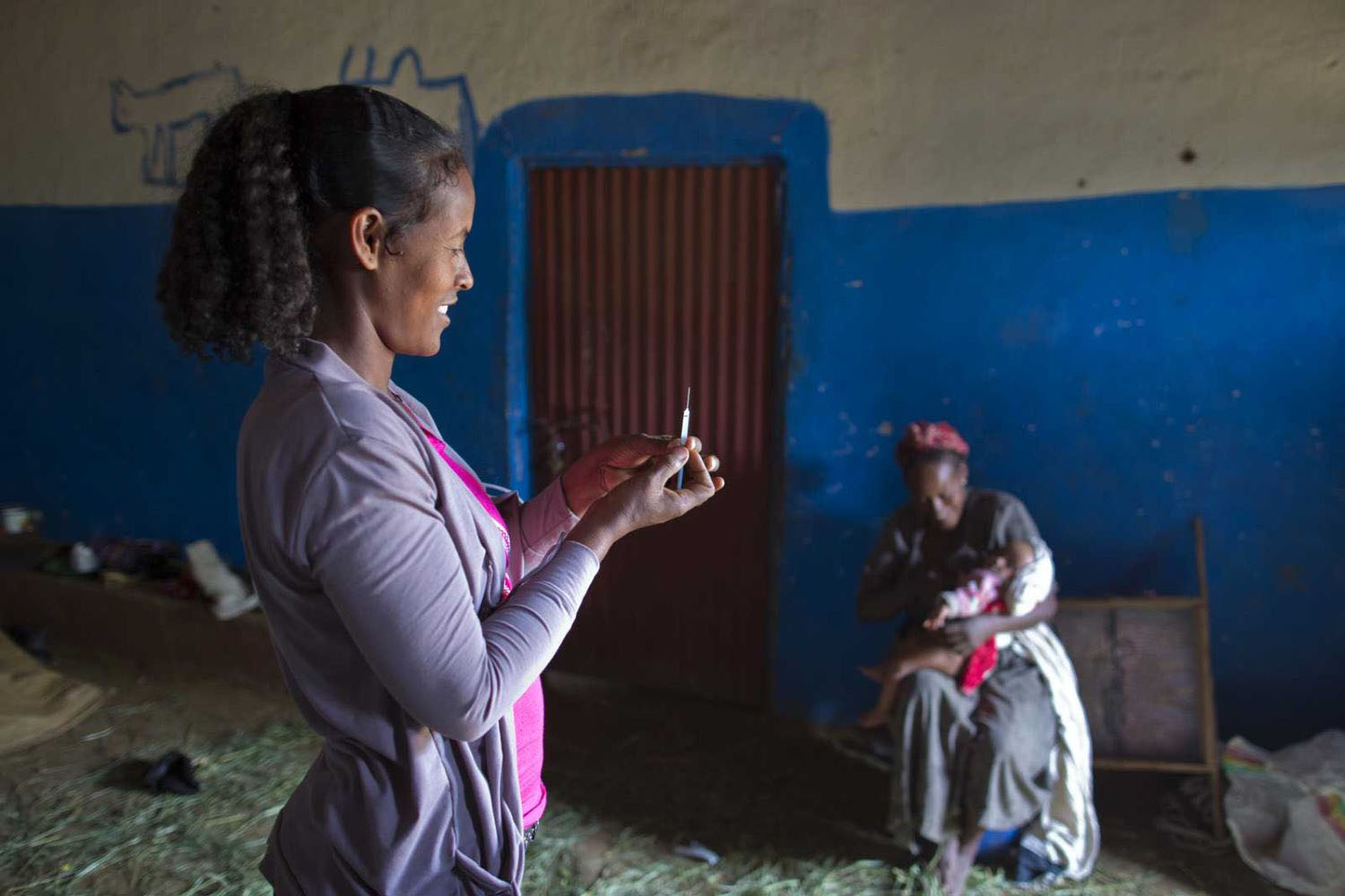 Gavi worker giving vaccine to newborn child