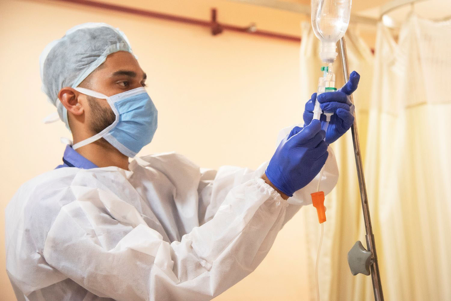 Doctor attaching needle to fluid bag