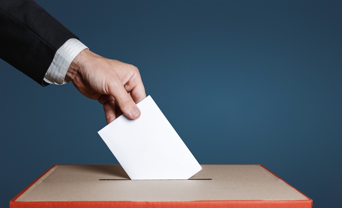Stock photo of a hand casting a ballot into a ballot box
