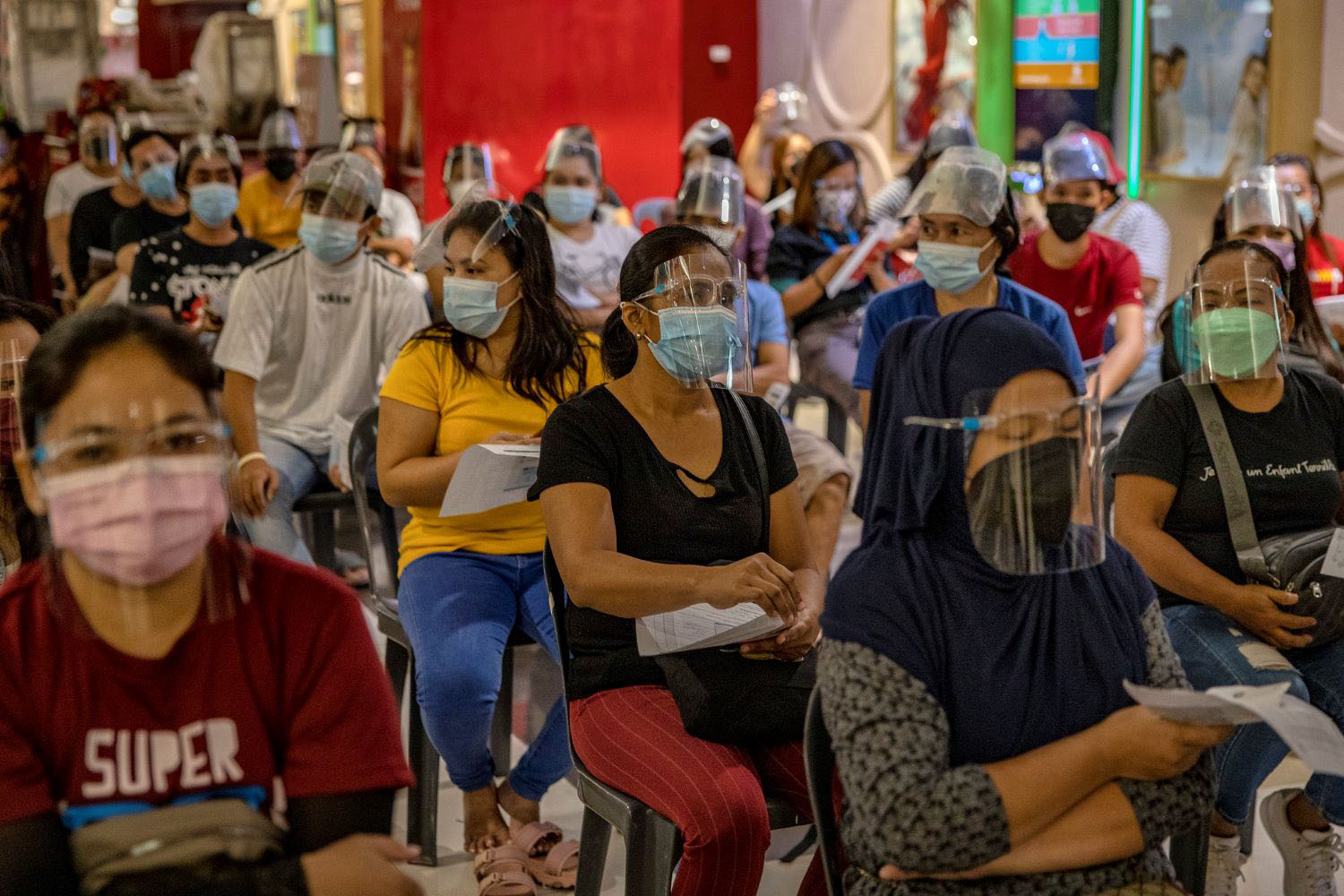 Marilyn Po queues to receive a dose of Moderna Covid-19 vaccine at a mall theatre