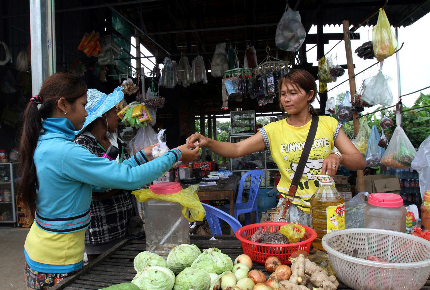Woman selling vegetables and other items in village