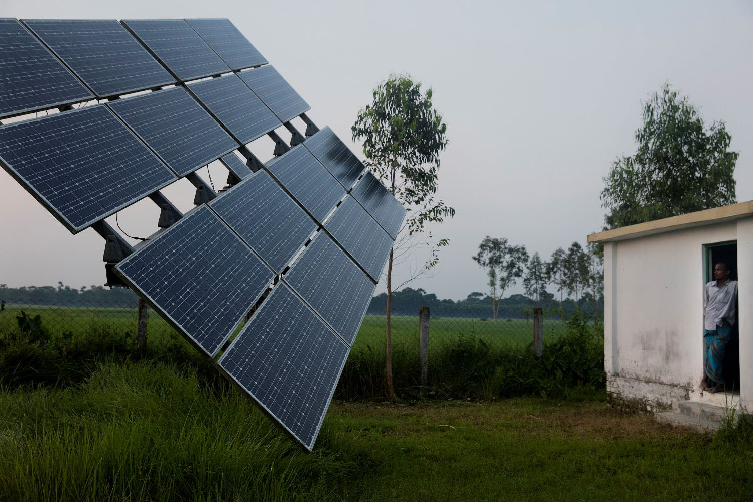 Manik, a solar pump operator for Nusra works near the solar panels in Rohertek, Bangladesh