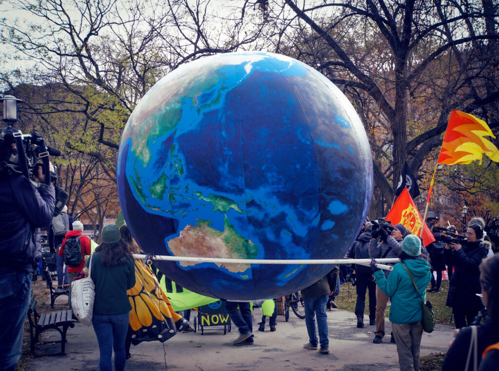 protesters holding up large globe