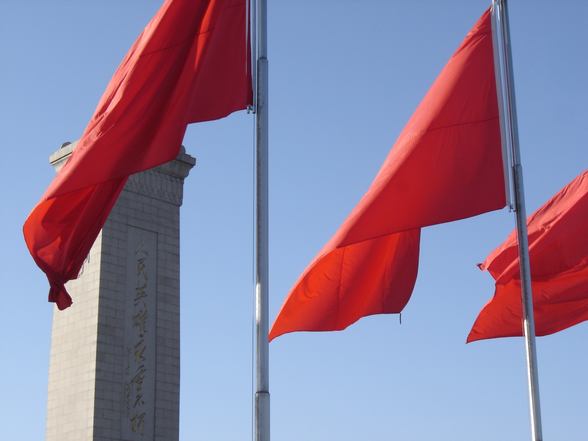 Chinese flags wave in front of monument