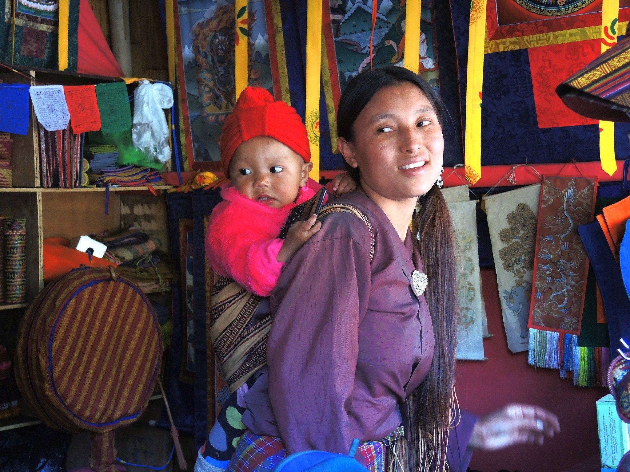 Bhutanese woman carries child on her back