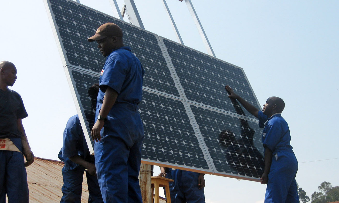 Workers installing solar panels at health clinic in Rwanda