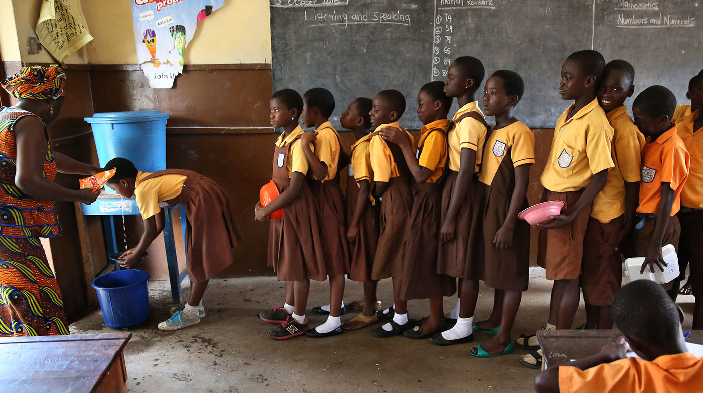 Students line up to wash hands before eating at primary school in Ghana