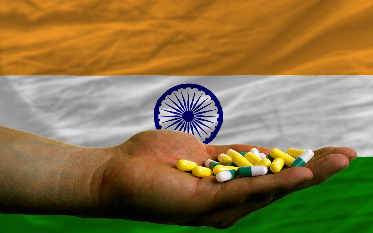 holding pills in hand in front of india national flag