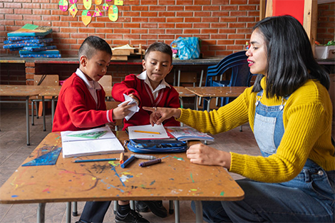 Teacher with two primary school students at school