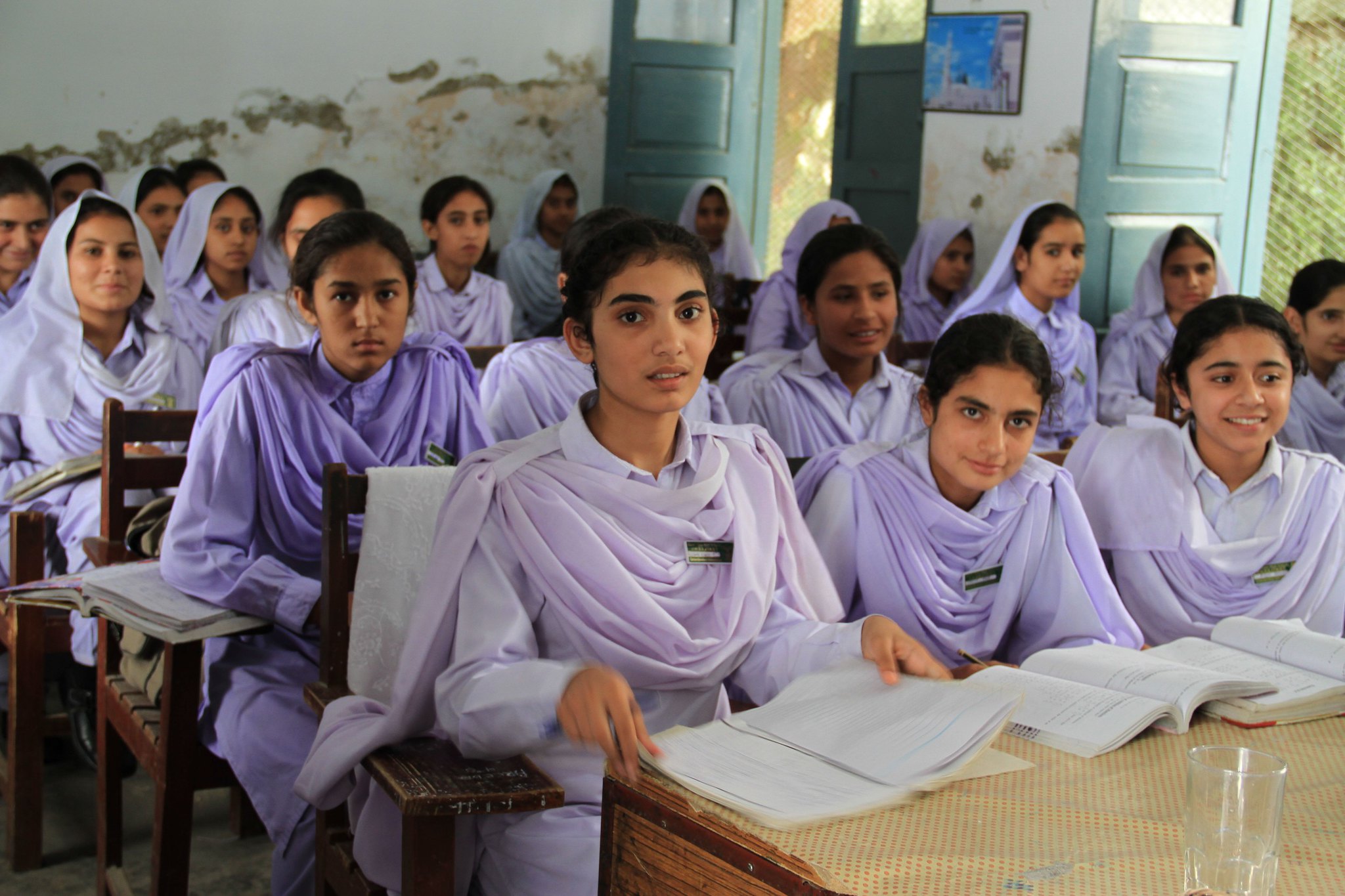 A classroom of Pakistani girl students look at camera