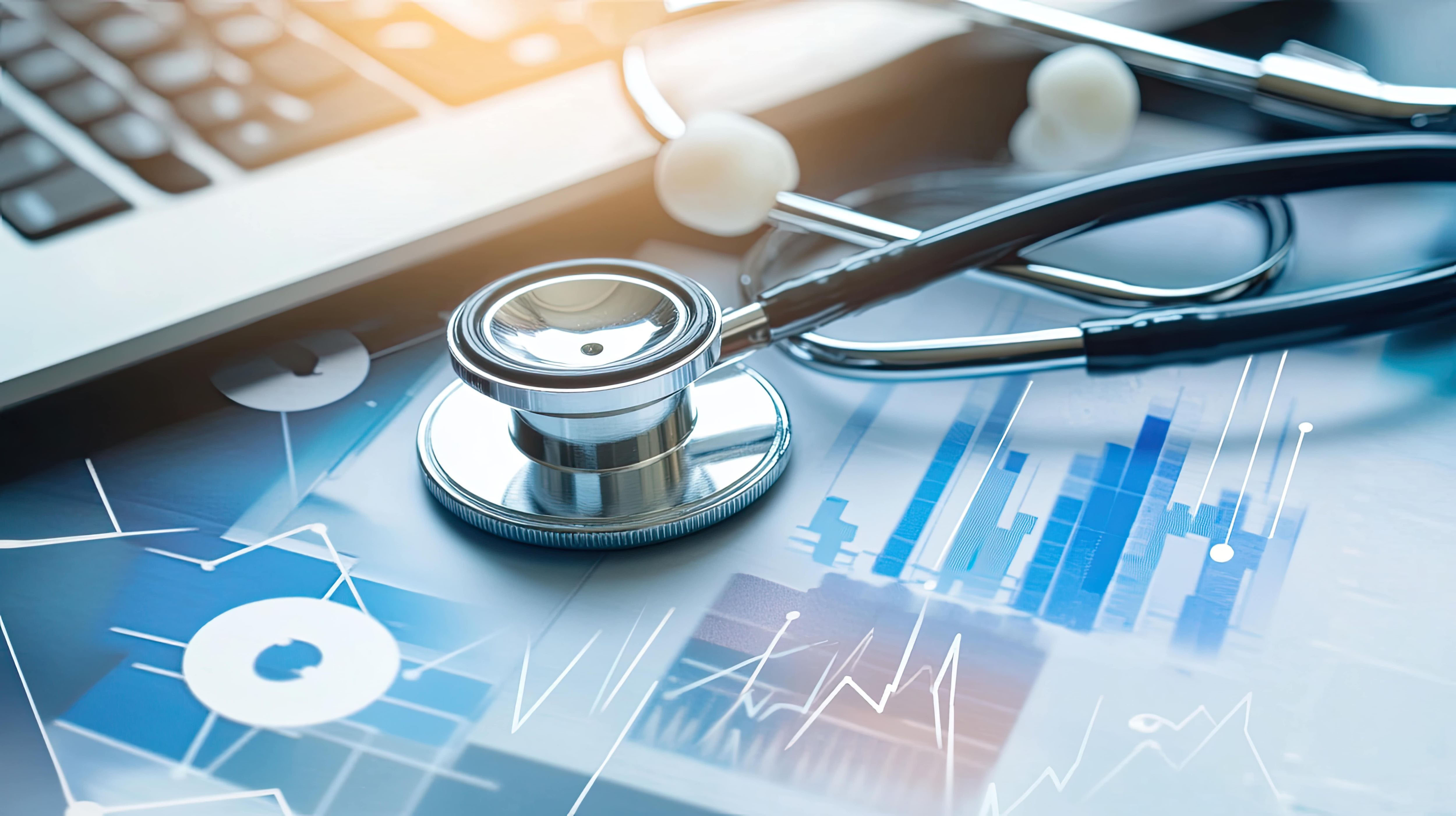 Laptop and stethoscope on top of sheets of data. 