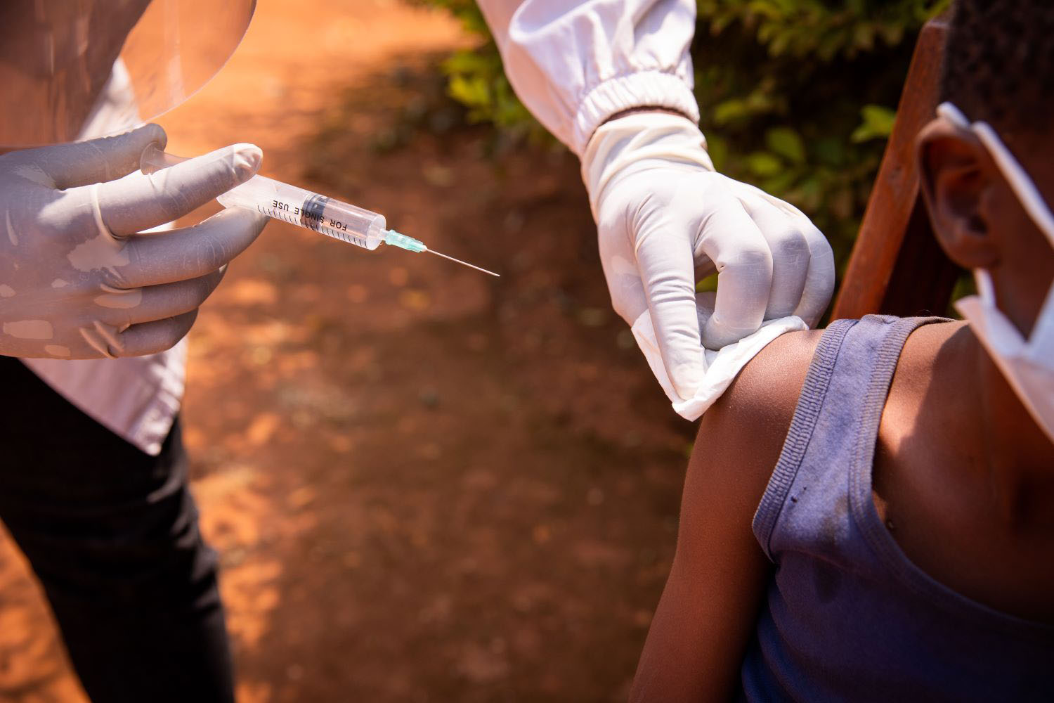 Close-up of a doctor's hand with a syringe about to inject a vaccine to a child