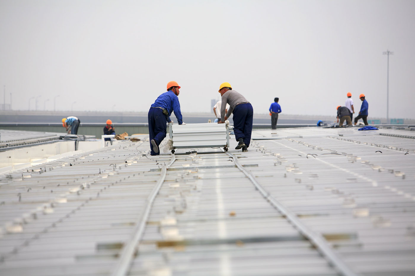 Chinese contractors installing solar panels on a solar farm