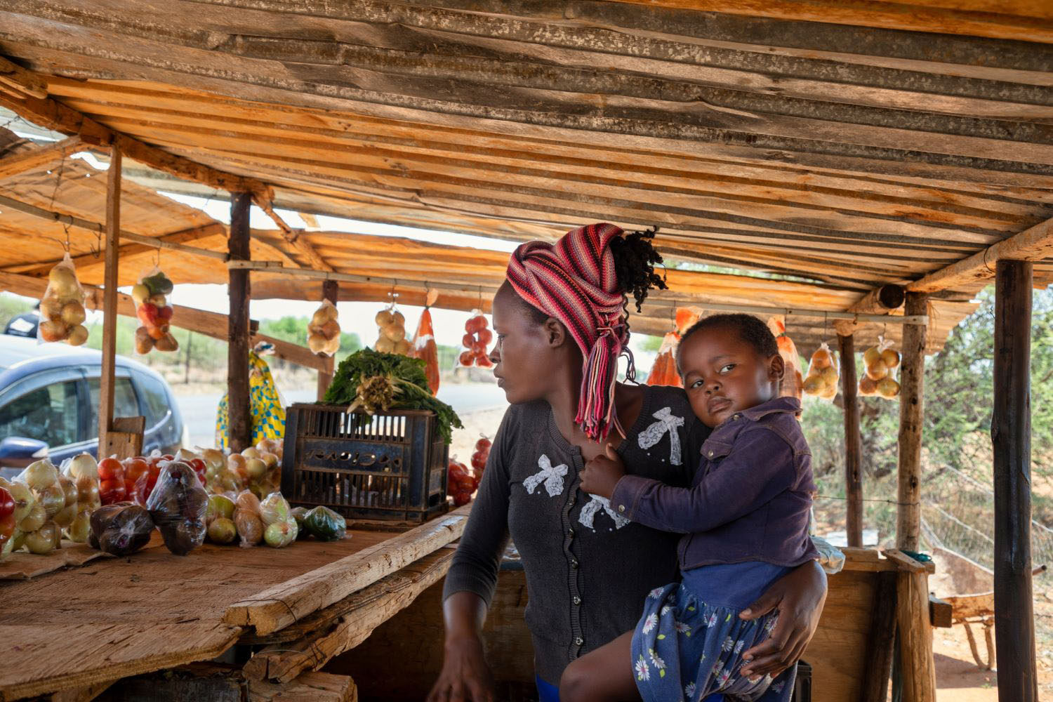 African street vendor selling fresh produce with son