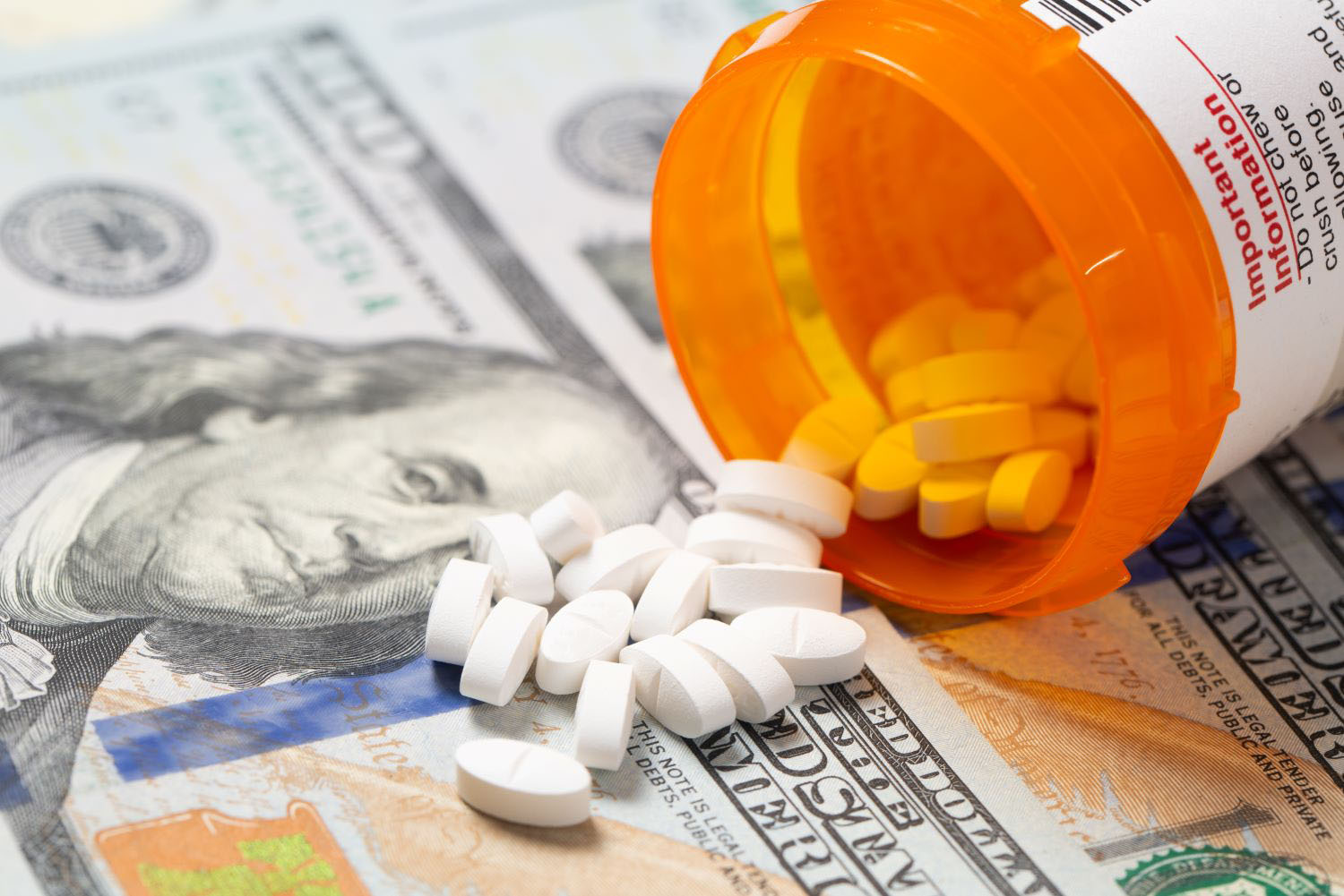 White pills on US hundred dollars bill