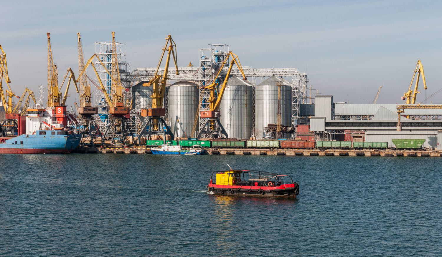 Seaport with industrial tanks cranes, storage areas, and support facilities. 