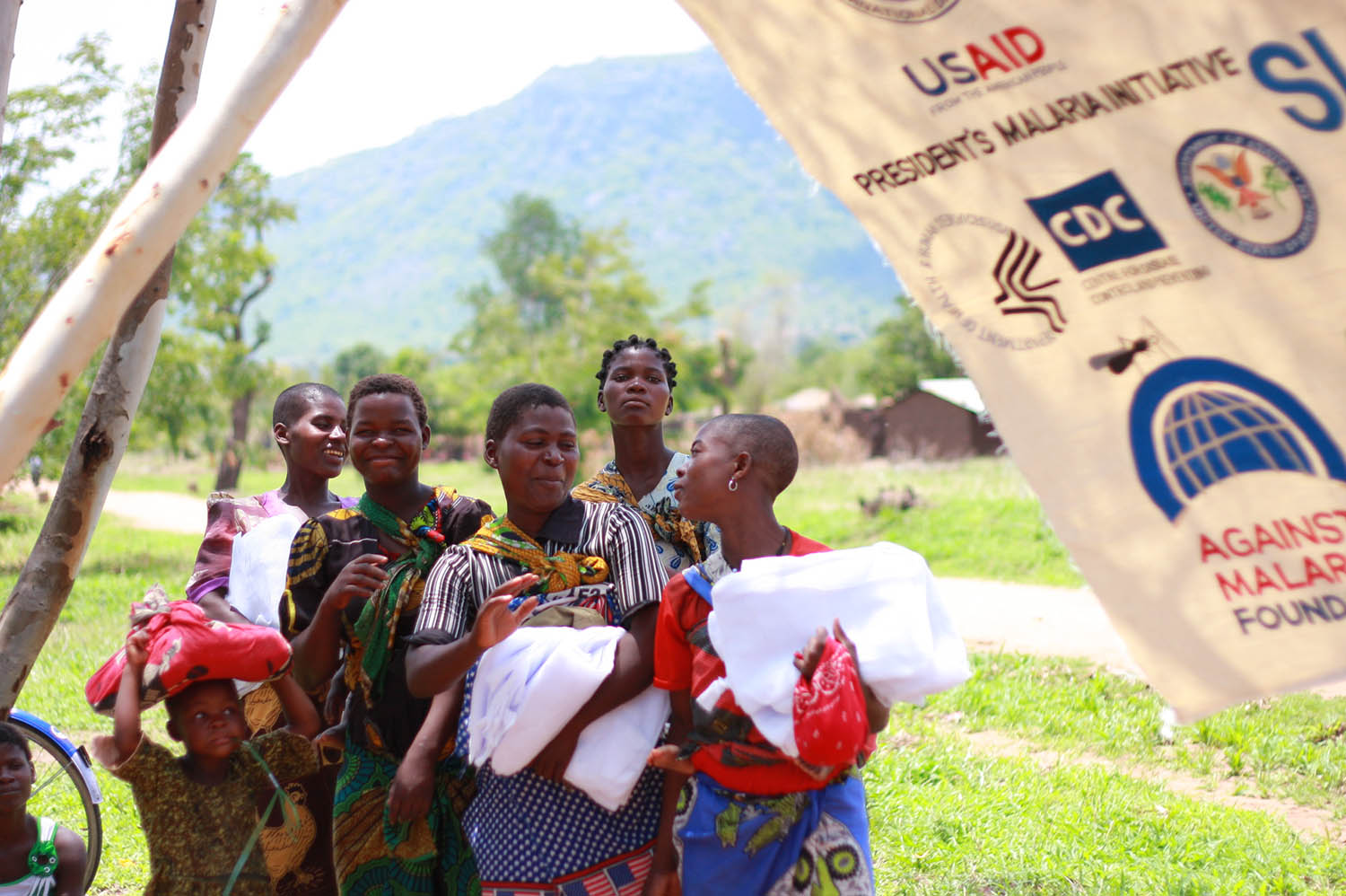 Women and children receive anti-malarial bednets as part of a public health program in Kalinde and Nambazo, Phalombe Nambazo North, Malawi