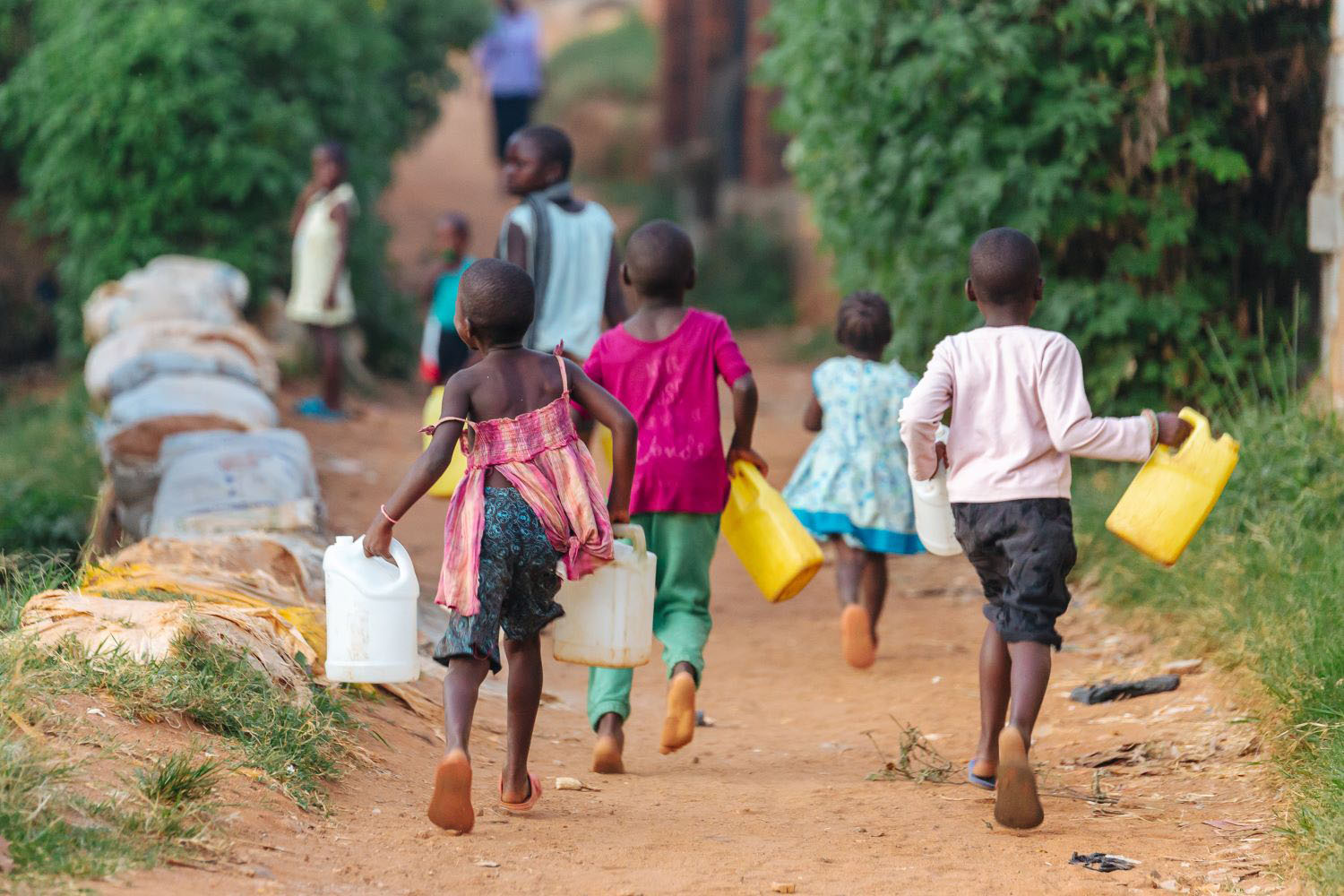 Children carrying water cans in Uganda