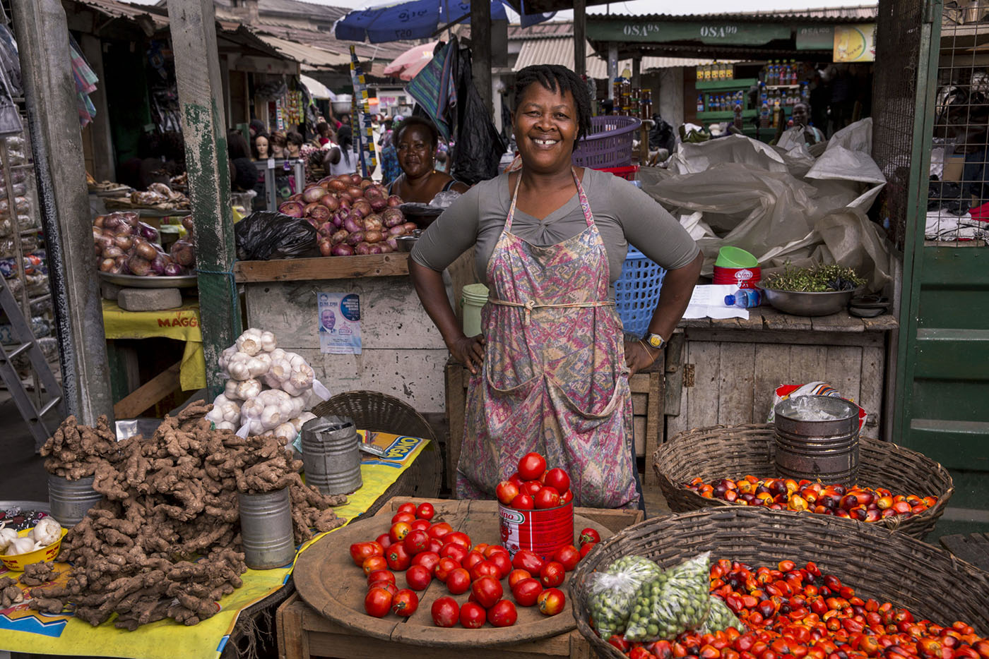 Market vendor stands proudly at her tomato stand in the Makola Market.