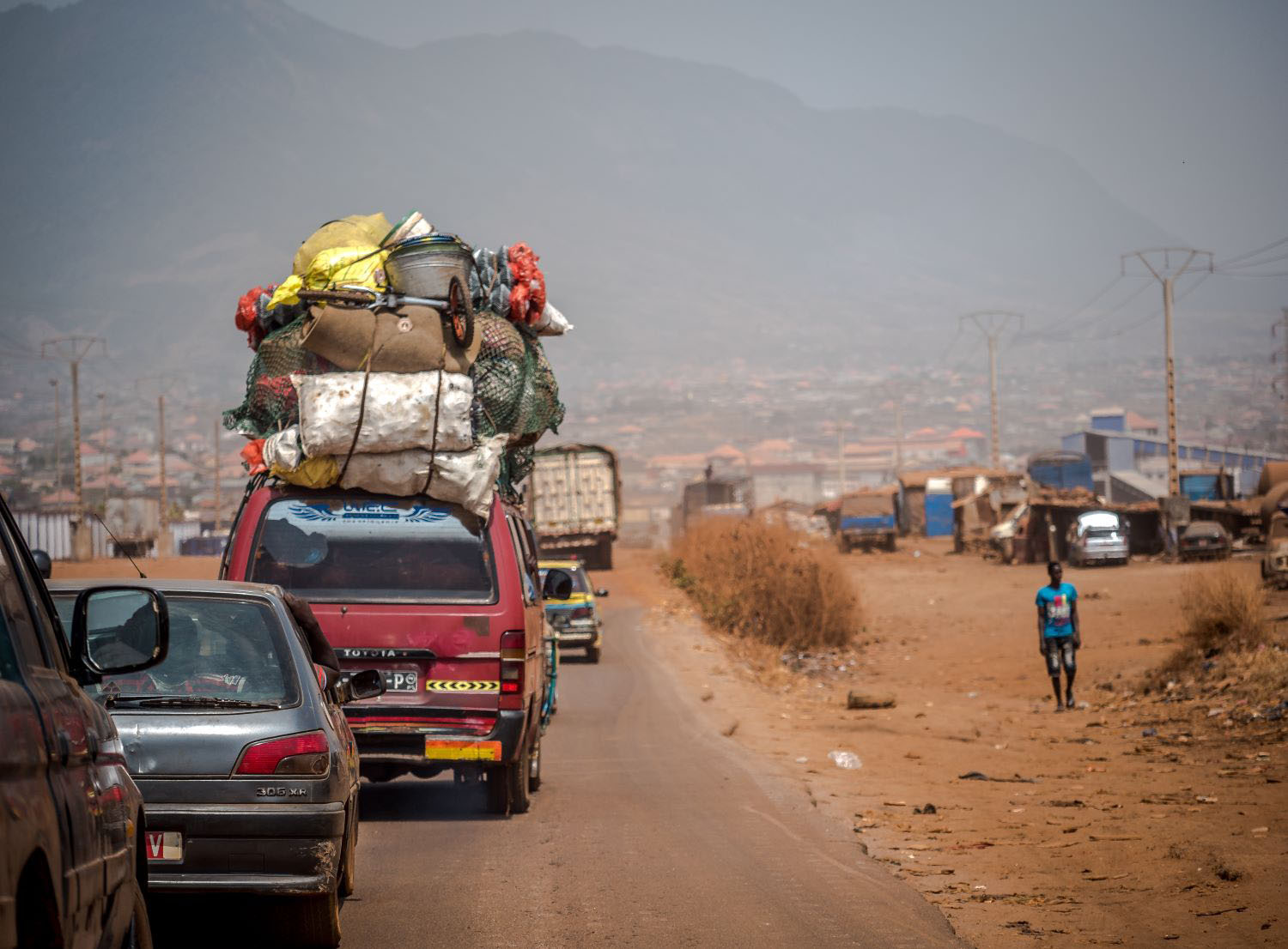 People on the street next to a bus loaded with parcels