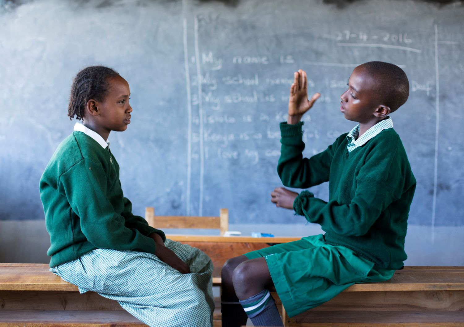 Children in a classroom learning sign language