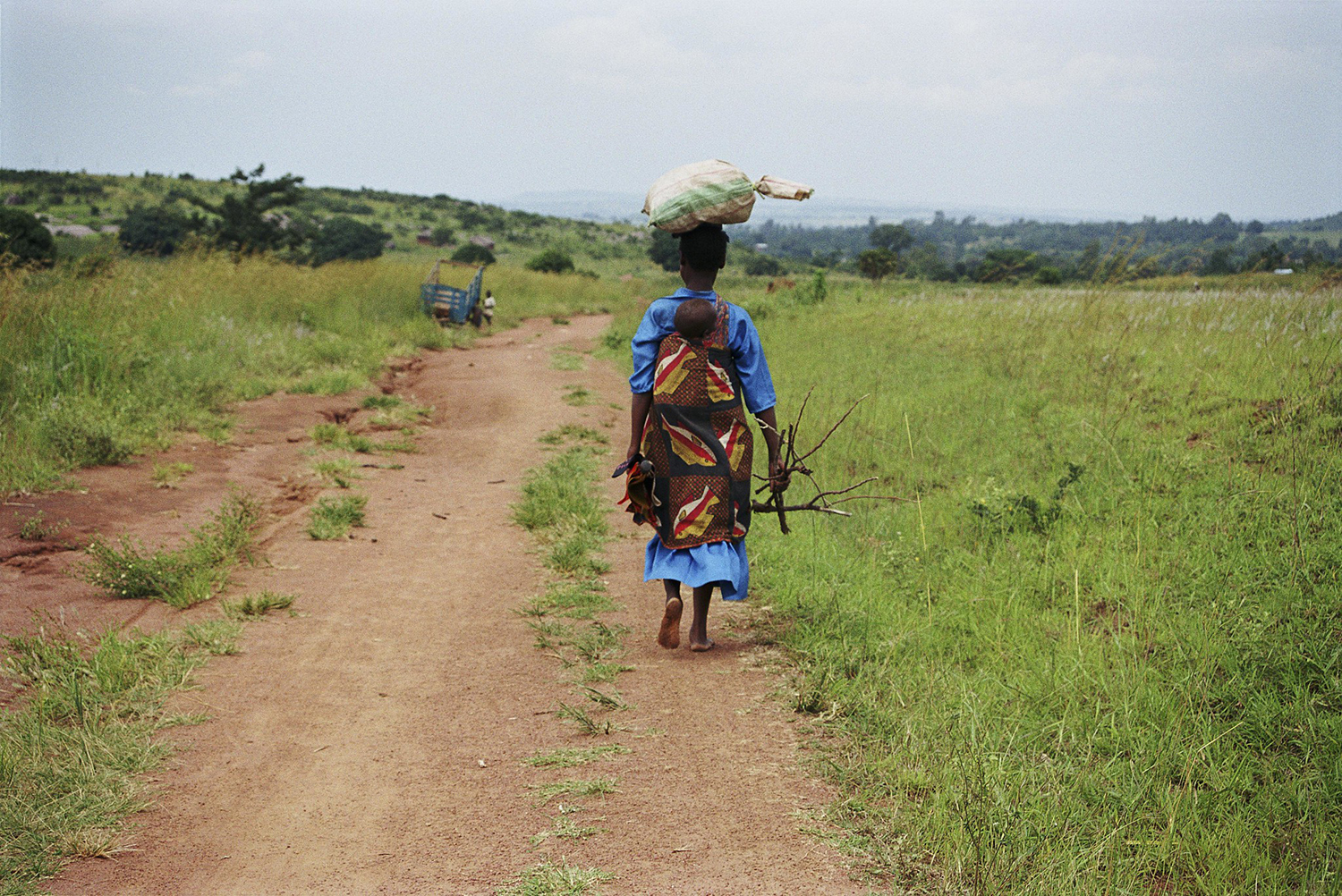 Young mother carries child on her back in rural Tanzania.