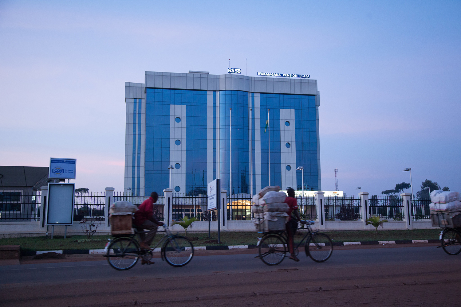 Cyclists take their goods to market in the early hours of the morning in Rwamagana, Rwanda