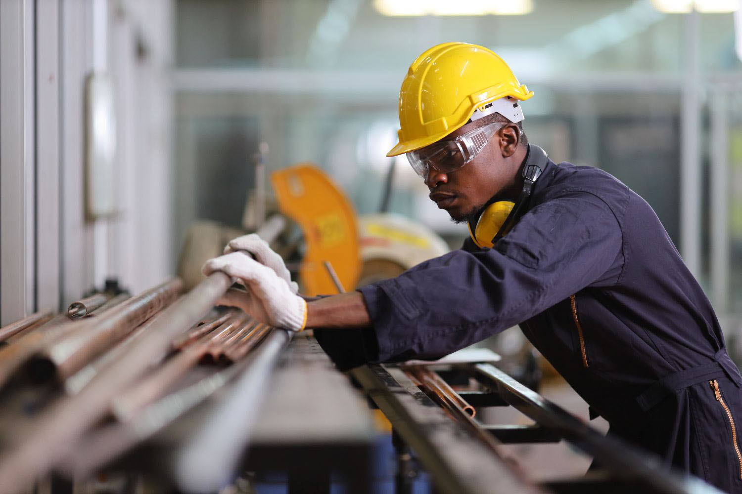 Mechanic engineer worker is choosing copper tube for sawing while working in coolant factory