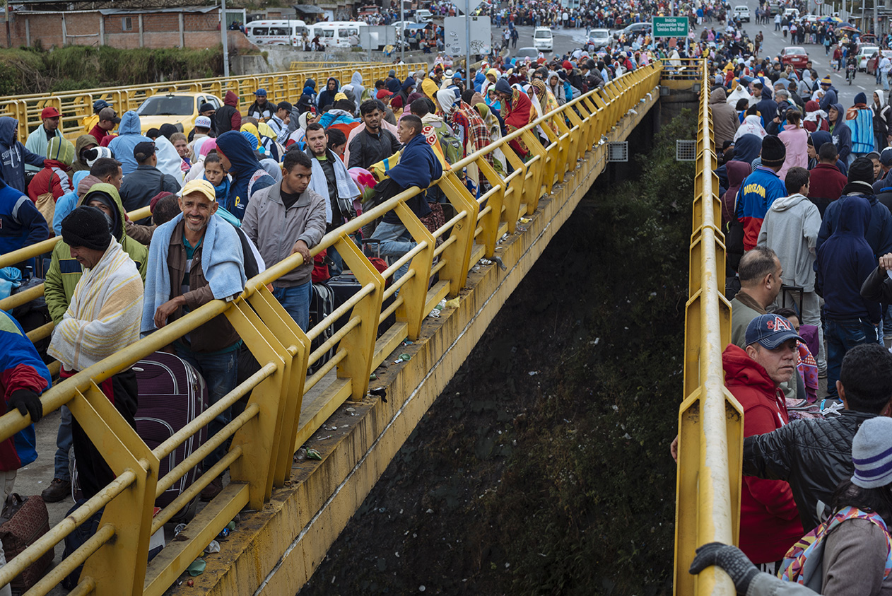 Venezuelan migrants wait in line to enter cross Ecuador's border