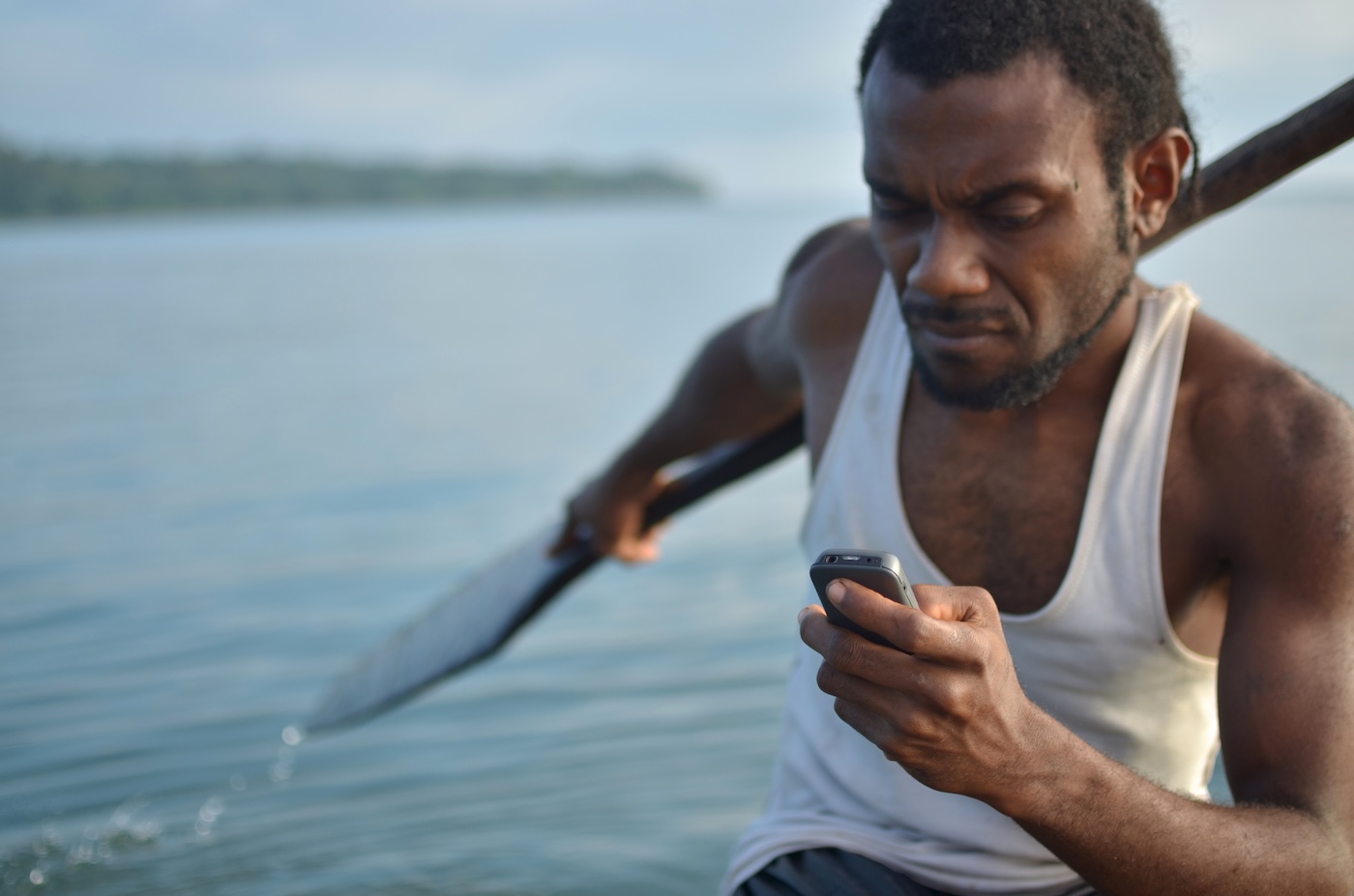 A fisherman in Vanuatu using a mobile phone