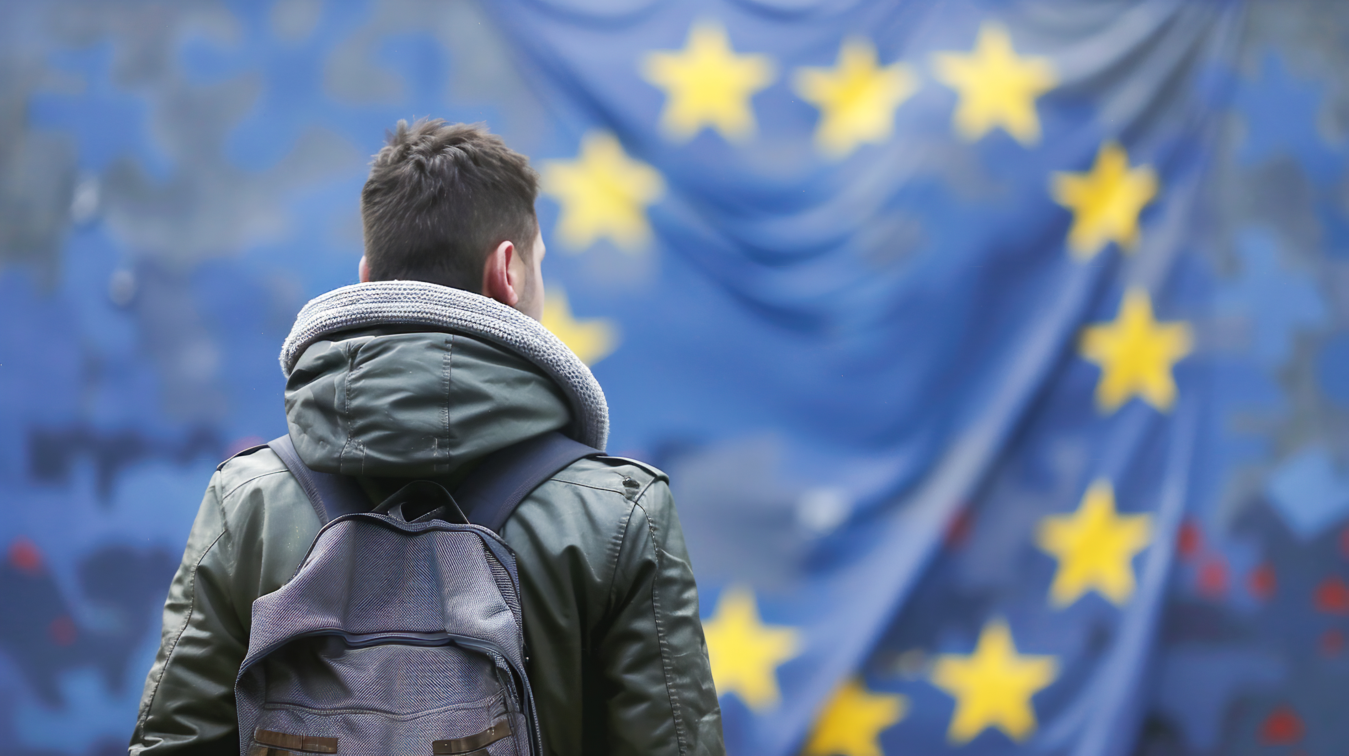 A man standing in front of the EU flag, with his back at the camera