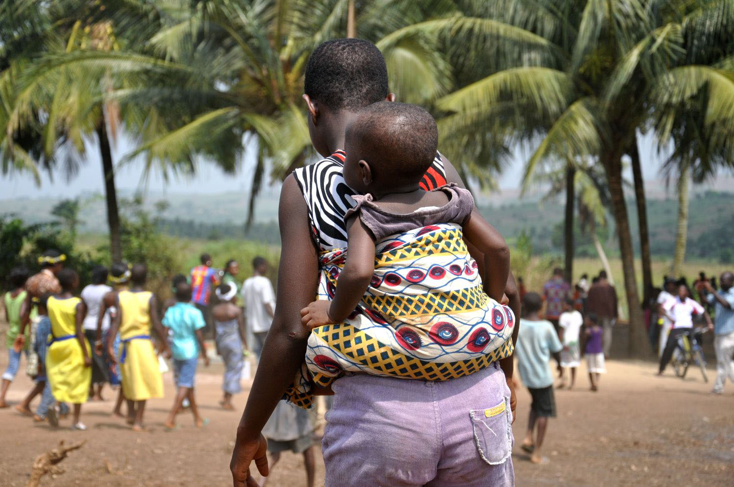 Ghana mother and child visit water pump provided by USAID.